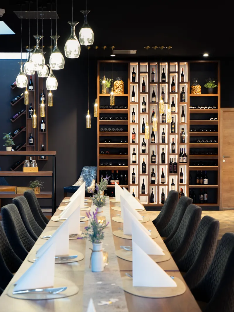 Festlich gedeckte Tafel in der Weinbar vor dem Weinregal