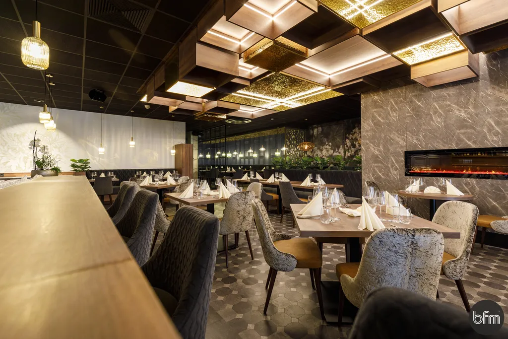 Gastraum des Restaurants Schöne Momente in Brake mit gedeckten Tischen, Samtstühlen und goldener Deckenbeleuchtung